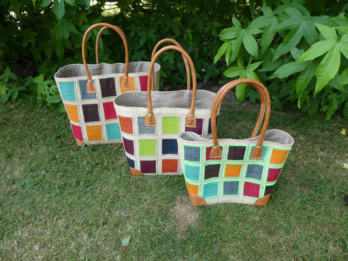 Cabas motif carré noir/blanc en cuir, panier artisanal trois tailles - photo de trois cabas tressés sur herbe