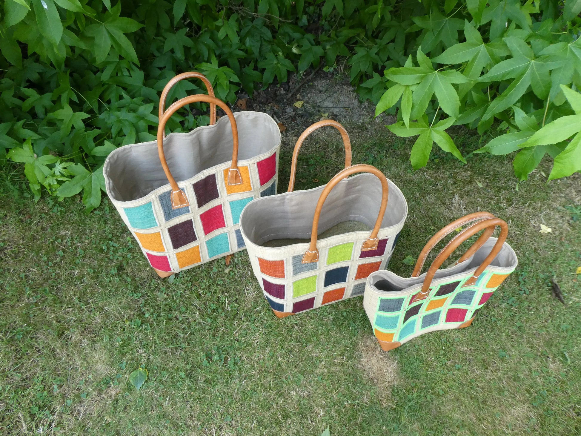 Cabas motif carré noir/blanc en cuir, panier artisanal trois tailles - vue du dessus des cabas sur herbe